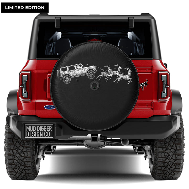Santa driving a Ford Bronco pulling reindeer, Christmas-themed spare tire cover for Ford Bronco